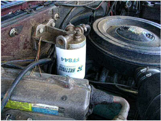 A fuel filter (white) next to the air filter compartment (circular black part) 